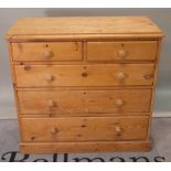 An early 20th century pine chest of two short and three long graduated drawers on plinth base,