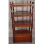 A late Victorian mahogany four tier what-not with cupboard base on turned supports,