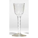 An opaque twist wine glass, circa 1765, the ogee bowl engraved with fruiting vine and a bird,