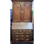 A mid-18th century mahogany bureau cabinet, the pair of panel doors over a fitted interior,