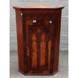 A 19th century oak and pollard oak Gothic Revival hanging corner cupboard,