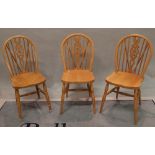 A set of eight 20th century beech wheel back dining chairs on turned supports,