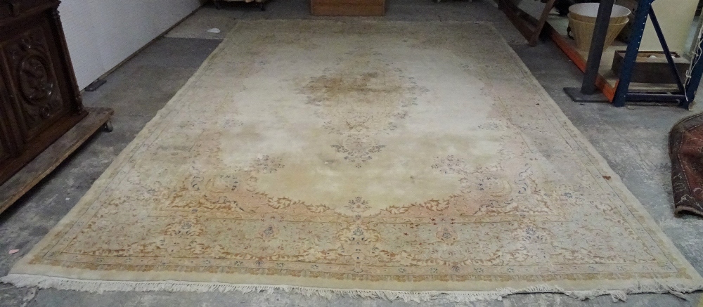 A Kerman carpet, Persian, the plain ivory field with an elongated floral medallion,