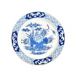 A large Bow blue and white plate, circa 1760-65, painted in the centre with a lotus flower,