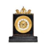 An Empire style ebonised mantel clock with twin gilt metal lion surmount and white enamel dial