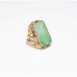 A gold and jade ring, the rectangular jade panel with carved and pierced decoration,