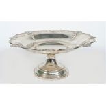 A silver pedestal dish, of shaped circular form, the rim decorated with scallop motifs at intervals,