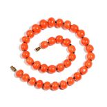 A single row necklace of graduated coral beads, on a base metal clasp,