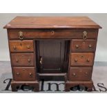 A late George III mahogany kneehole desk, with seven drawers about the knee on bracket feet,