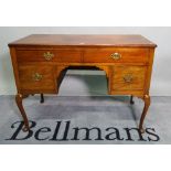 An Edwardian mahogany kneehole writing desk with four drawers about the knee,