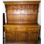 A 20th century pine kitchen dresser with a three tier plate rack over three short drawers,