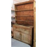 A 20th century pine dresser with three tier plate rack over cupboard base, 140cm wide x 240cm high.