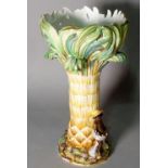 A Continental ceramic centrepiece, formed as a palm tree with figures beneath, 36cm high.