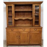 A 20th century pine kitchen dresser, the two tier plate rack flanked by cupboard doors,