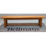 A 20th century oak bench on block supports, 180cm wide x 44cm high.