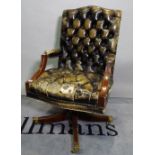 A studded green leather upholstery open arm office swivel chair on four downswept supports,
