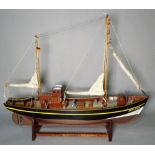 A modern wooden model of a boat on a stand, 49cm long.