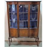 An Edwardian inlaid mahogany display cabinet, the serpentine front with a pair of semi-glazed doors,