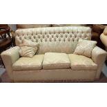 A 20th century hardwood framed two seater sofa with green foliate upholstery,