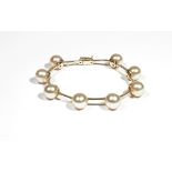 A gold and cultured pearl-set bracelet by Autore, set with eight cultured pearls,