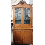 A 19th century Continental display cabinet/cupboard with a pair of glazed doors over a pair of