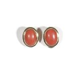 A pair of Italian gold and coral earclips, each mounted with an oval cabochon coral, detailed 750,