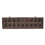 A set of three Middle Eastern metal wall hooks, mounted on a hardwood rectangular wall plaque,