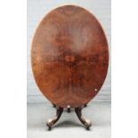 A Victorian figured walnut, oval snap top centre table, on four carved downswept supports,