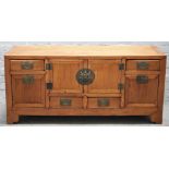 A 19th century Chinese elm low cabinet, with a pair of cupboards and six drawers,