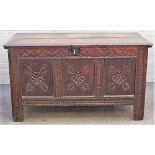 A 17th century oak coffer, the twin plank lid over carved triple front, 129cm wide x 73cm high.