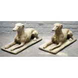 A pair of reconstituted stone figures of recumbent greyhounds on rectangular bases,