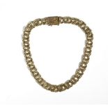 A gold bracelet, in an entwined double link design, on a snap clasp, detailed 10 KT, length 18.