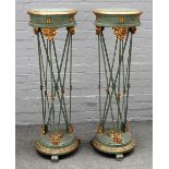 A pair of 18th century style parcel gilt green painted circular torchere stands,