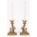 A pair of Regency style gilt bronze candlesticks with recumbant stag and deer to the stepped