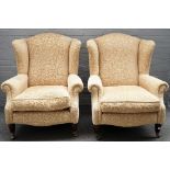 A pair of 20th century wingback armchairs, on tapering fluted supports, 80cm wide x 102 cm high.