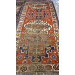 A Kazakh rug, Caucasian, the madder field with two large ivory and two large indigo medallions,