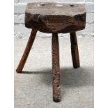 A 19th century primitive oak stool/chopping block, on three staked supports, 33cm wide x 44cm high.