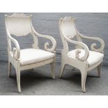 A pair of 19th century later painted Swedish open armchairs on sabre supports,