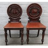 A pair of Victorian mahogany oval back hall chairs, on turned supports, 42cm wide x 86cm high.