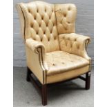 A mid-18th century style beige leather upholstered wingback armchair, on square supports,