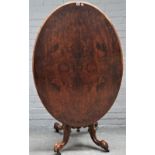 A Victorian figured walnut oval snap top loo table on four carved supports, 122cm wide x 71cm high.