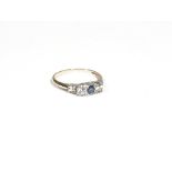 A gold, sapphire and diamond three-stone ring, the central circular-cut sapphire,