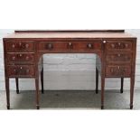 Probably Waring & Gillows; an inlaid mahogany seven drawer writing desk, on square supports,