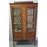 An Edwardian marquetry inlaid mahogany two door display cabinet, on square supports,