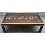 A brass bound rectangular coffee table, inset with relief of a medieval battle scene,