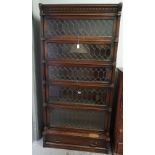 A carved oak Globe Wernicke five tier bookcase, with fluted pilasters,