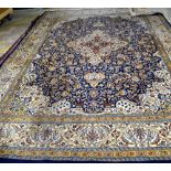 An Indian carpet, the indigo field filled with floral sprays, a central ivory border,