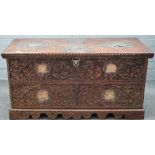 A 19th century Indian brass and copper mounted, carved hardwood trunk with shaped plinth,