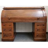 A late 19th century oak cylinder desk with fitted interior over six pedestal drawers,