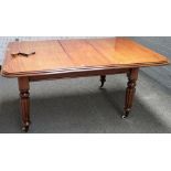 A Victorian mahogany extending dining table, on reeded supports, with one extra leaf,